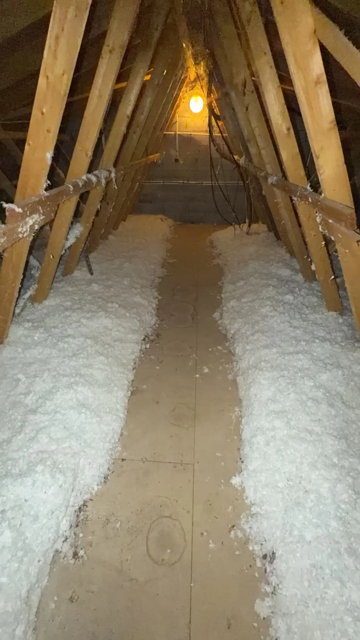 Combles sous charpente bois, isolant soufflé de part et d’autre de la passerelle